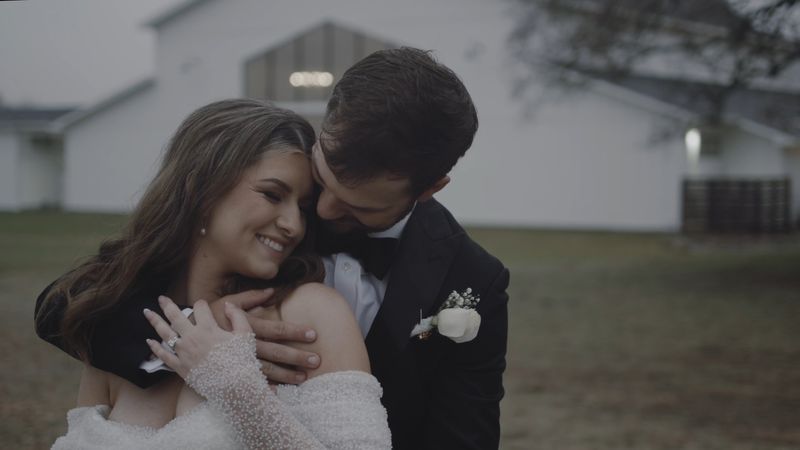Bride and groom share a cinematic embrace beneath an oak tree at twilight